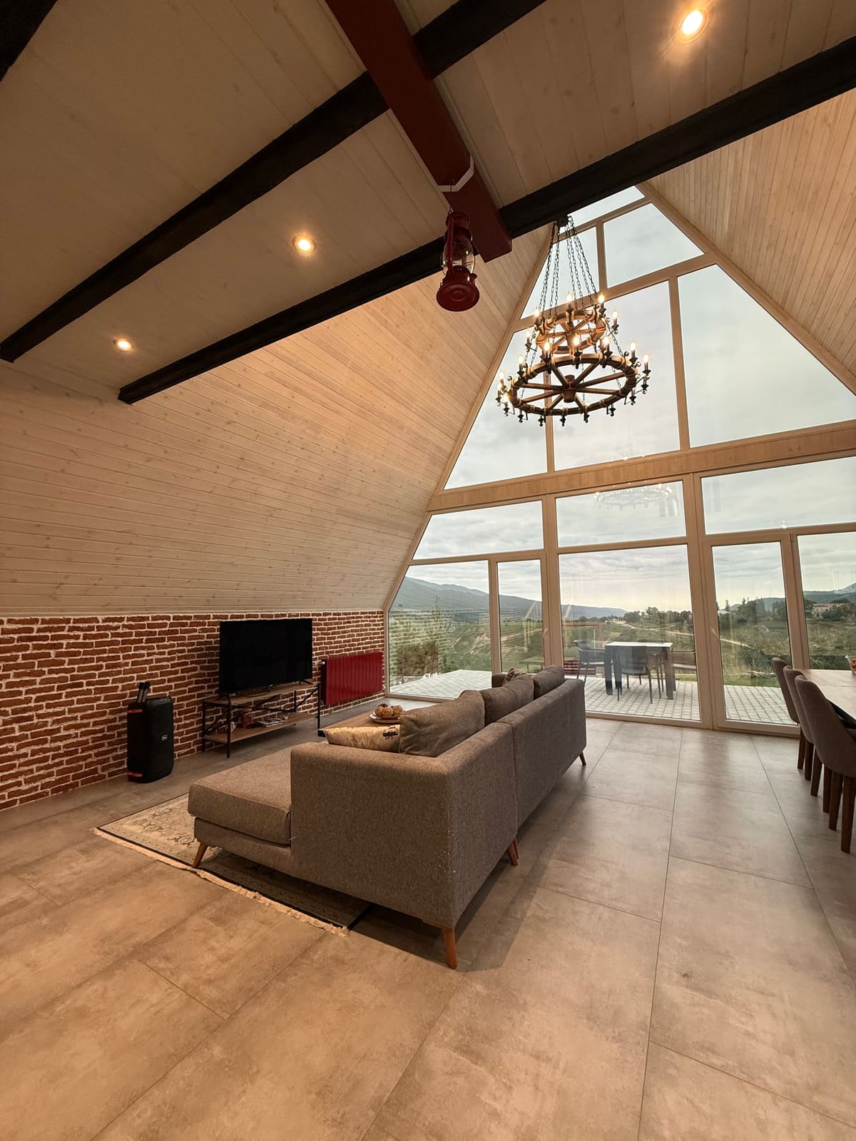 Living room with a corner sofa, ceiling beams and panoramic glazing