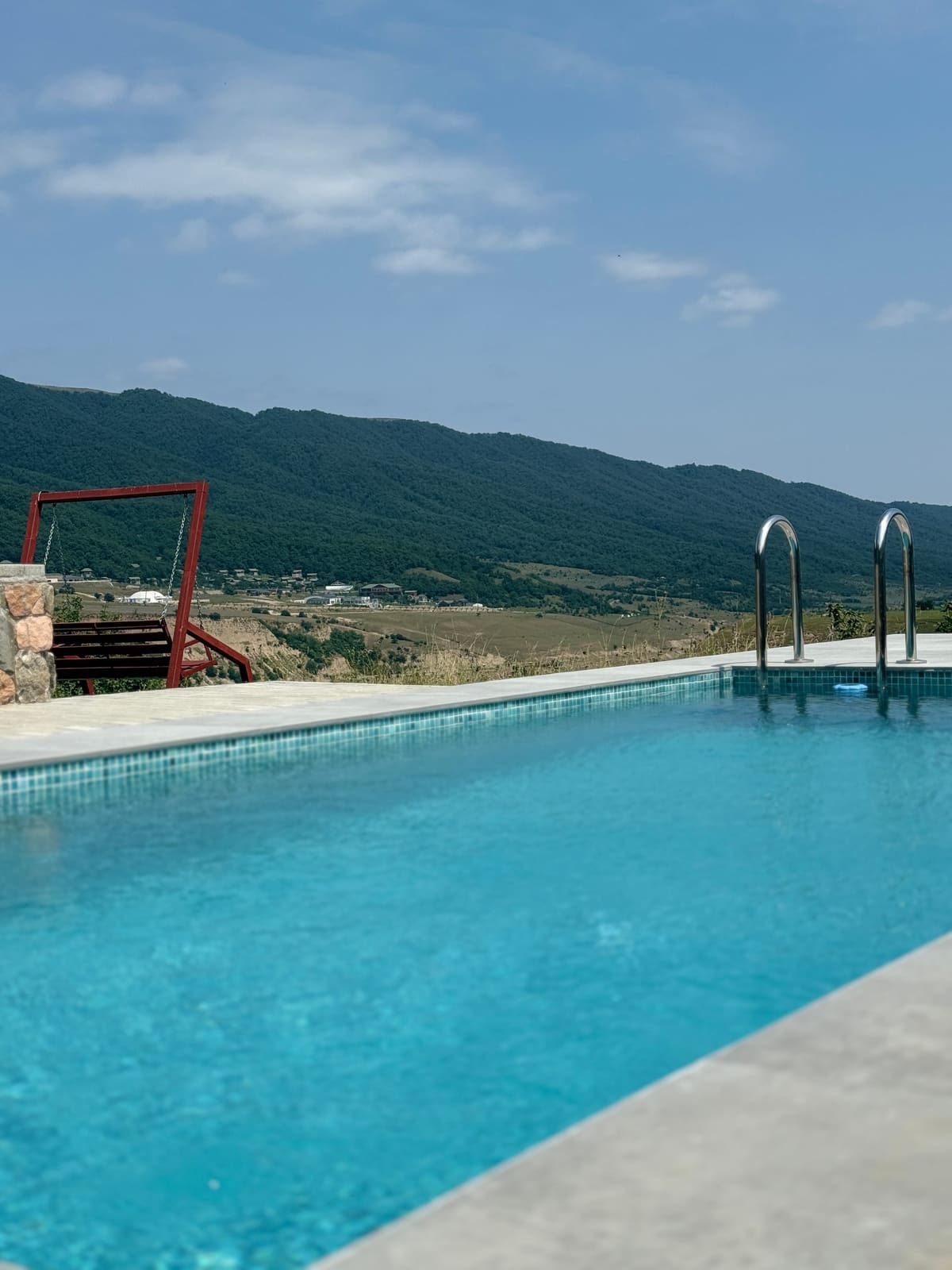 The pool with turquoise water and mountains in the distance