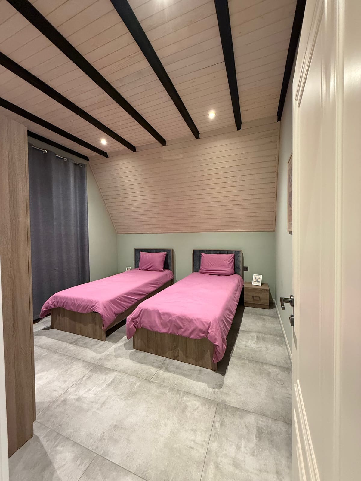 Second bedroom with two single beds under the sloping roof