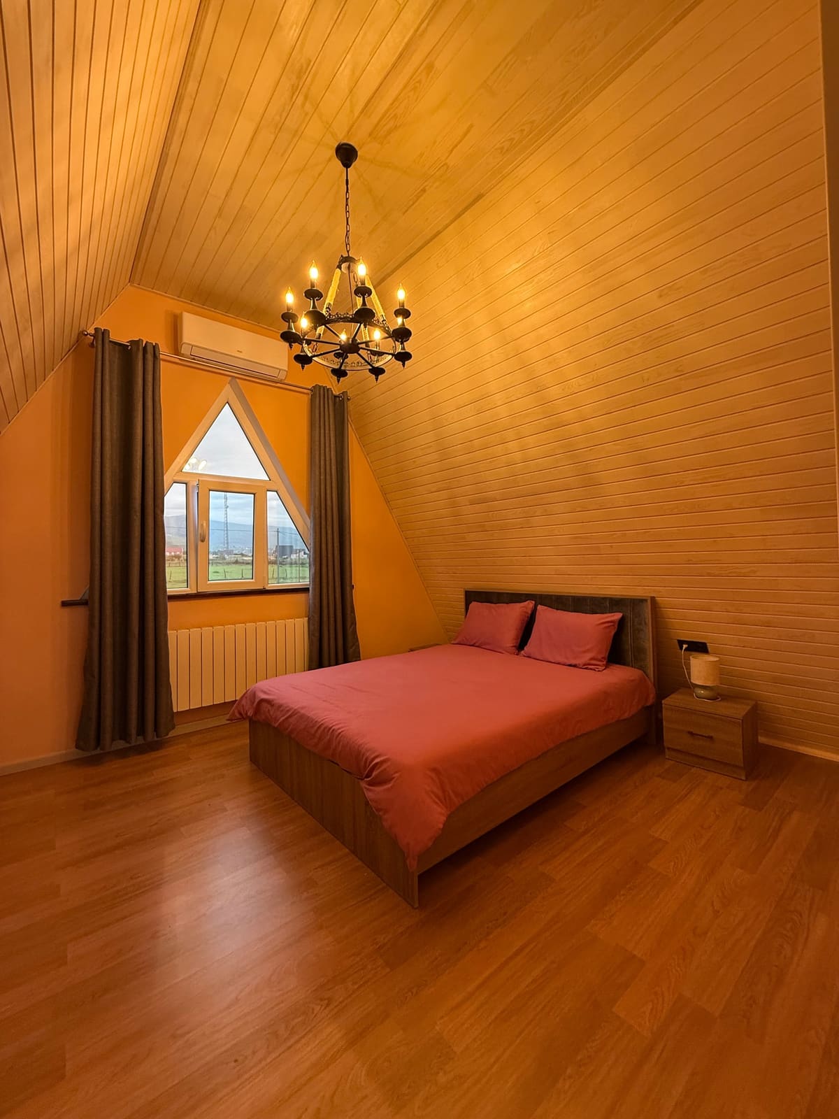 Bedroom with a double bed and a triangular window